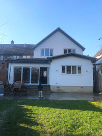 House exterior with a large glass door and windows on a clear day