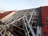 Roof construction with metal framework against a clear sky