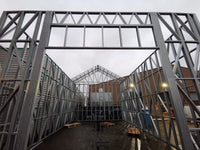 Metal framework structure with a building in the background
