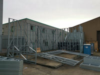 Metal frame structure on a concrete surface with buildings in the background
