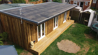 Wooden extension with a deck on a grassy area