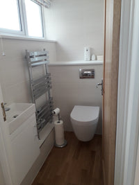 Bathroom setup with a toilet, sink, and towel rack.