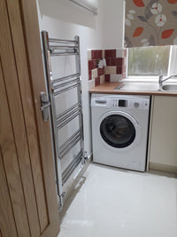 Washing machine installed in a kitchen cabinet with a wooden countertop.