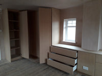 Unfinished room with wooden cabinets and a window.