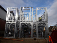 Metal frame structure under construction against a blue sky