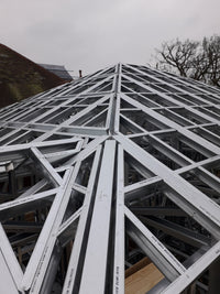 Geometric metal structure with a spherical design against a cloudy sky