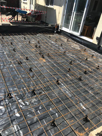 Construction site with metal frame and stone wall