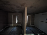 Dark room with a central pillar and light streaming through a window.