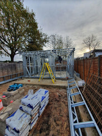 Construction site with metal frame structure and building materials outdoors.