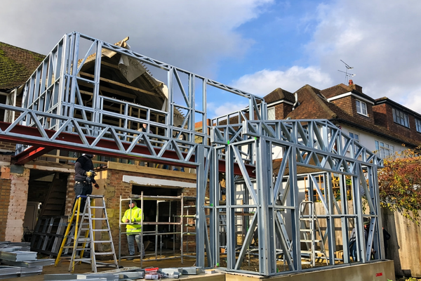 Construction site with a metal frame structure against a blue sky.