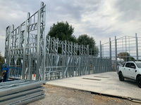 Construction site with metal frame structure and white truck