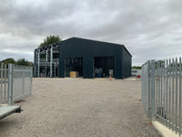 Modern industrial building with a metal facade on a cloudy day.