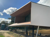 Modern house under construction with a clear blue sky