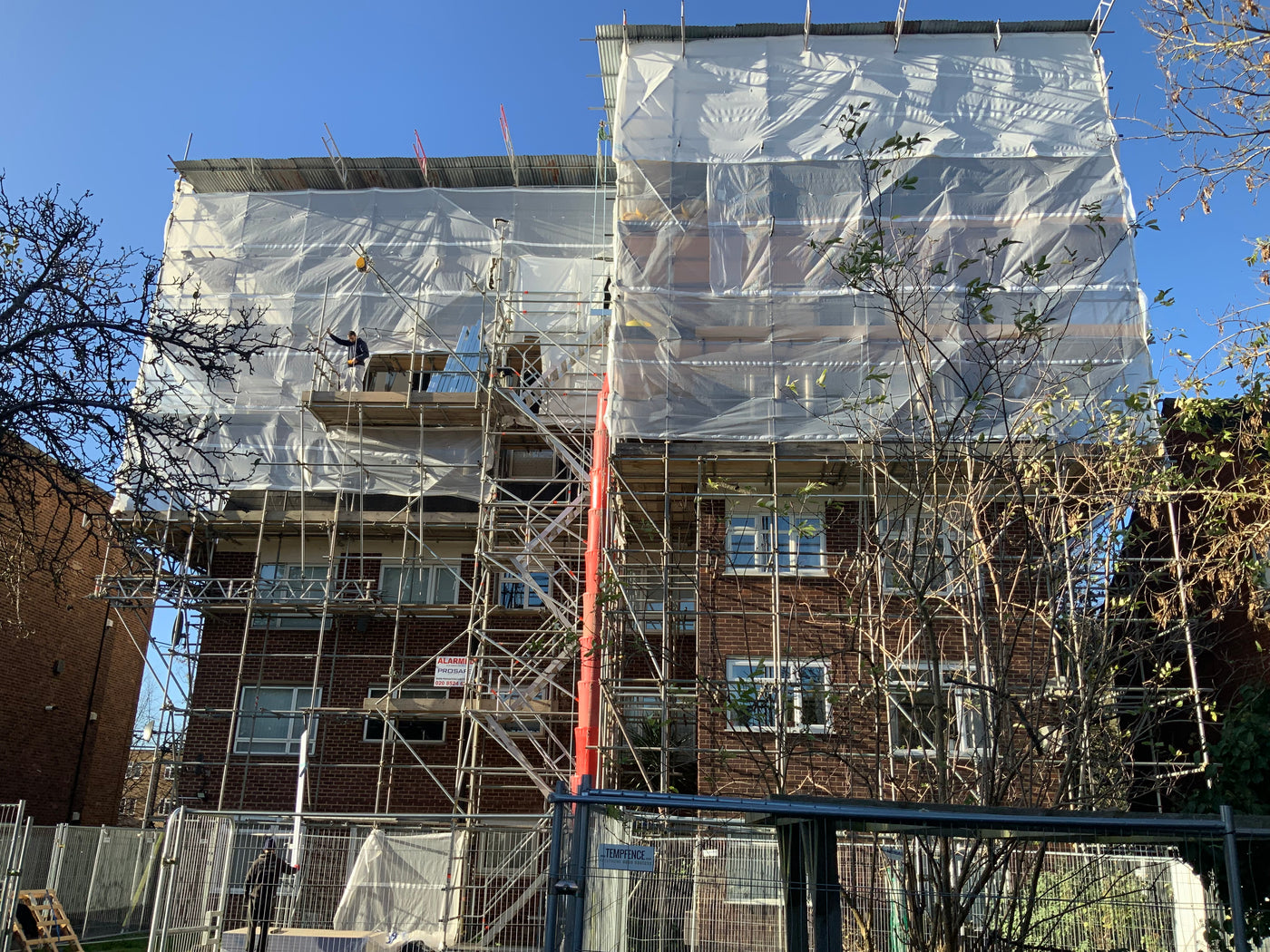 Building under construction with scaffolding and safety netting.