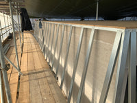 Metal frame structure on a wooden platform with scaffolding in the background