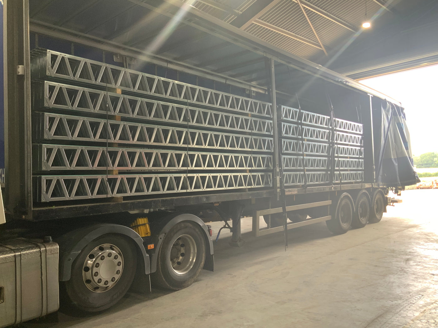 Trailer truck with a large number of metal frames on a road