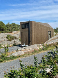 Wooden cabin on a rocky outcrop with a clear blue sky