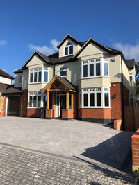 Two-story house with a driveway and clear blue sky