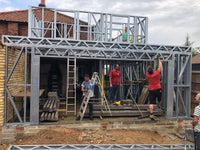 Construction site with metal frame and stone wall