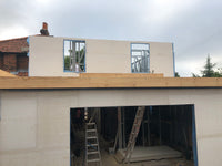 Construction site with metal frame and stone wall