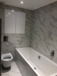Bathroom with tiled walls and ceiling, featuring a sink and toilet.