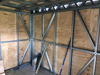 Structural metal frame with wooden panels inside a building under construction
