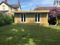 Wooden shed with glass doors in a garden setting