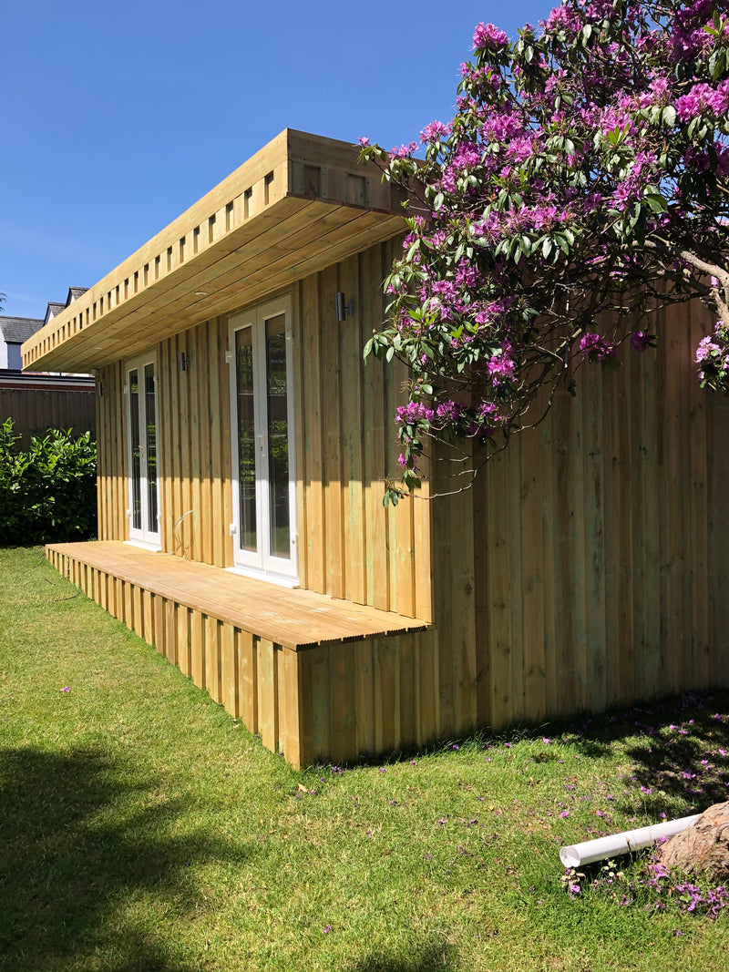 Wooden cabin with purple flowers and green grass