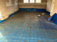 Room with a floor covered in blue protective sheeting and yellow grid pattern