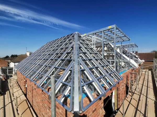 Construction site with a metal roof frame against a blue sky