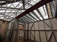 Underconstruction building with metal framework and beige panels.