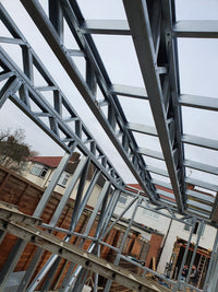 Metal roof structure with residential houses in the background