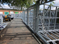 Metal frame structure on a construction site with a forklift in the background.