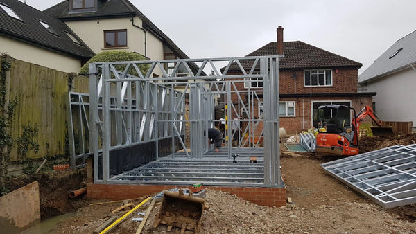 Construction site with a metal frame structure in a residential area